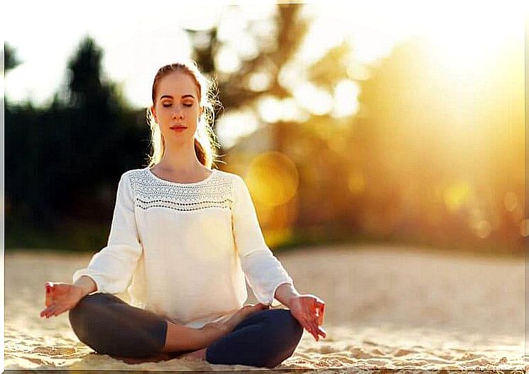 Woman meditating on the beach