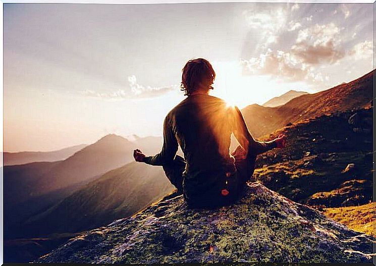 Person meditates on a mountain