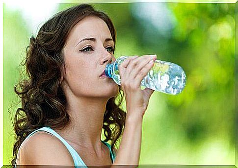 woman drinking from a plastic bottle