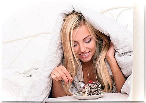 Woman eating cake in bed