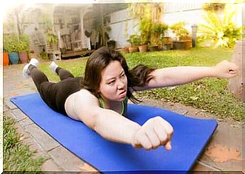 A woman is exercising against scoliosis in the garden