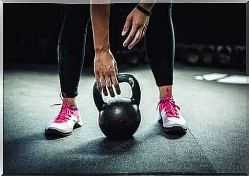 A person lifts a kettlebell