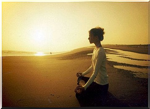 Woman meditating on the beach