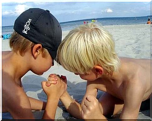 Going to the beach: Two children challenge each other's strength.