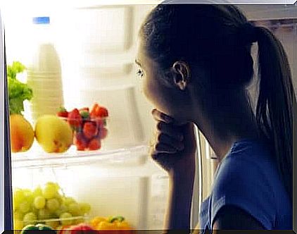 woman deciding what to eat in front of the fridge