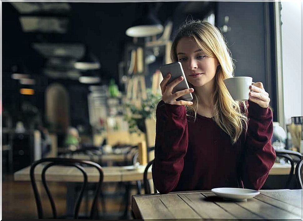 Woman in cafe depends on her mobile phone