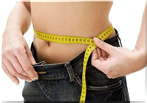 Measuring tape around the waist shows weight loss